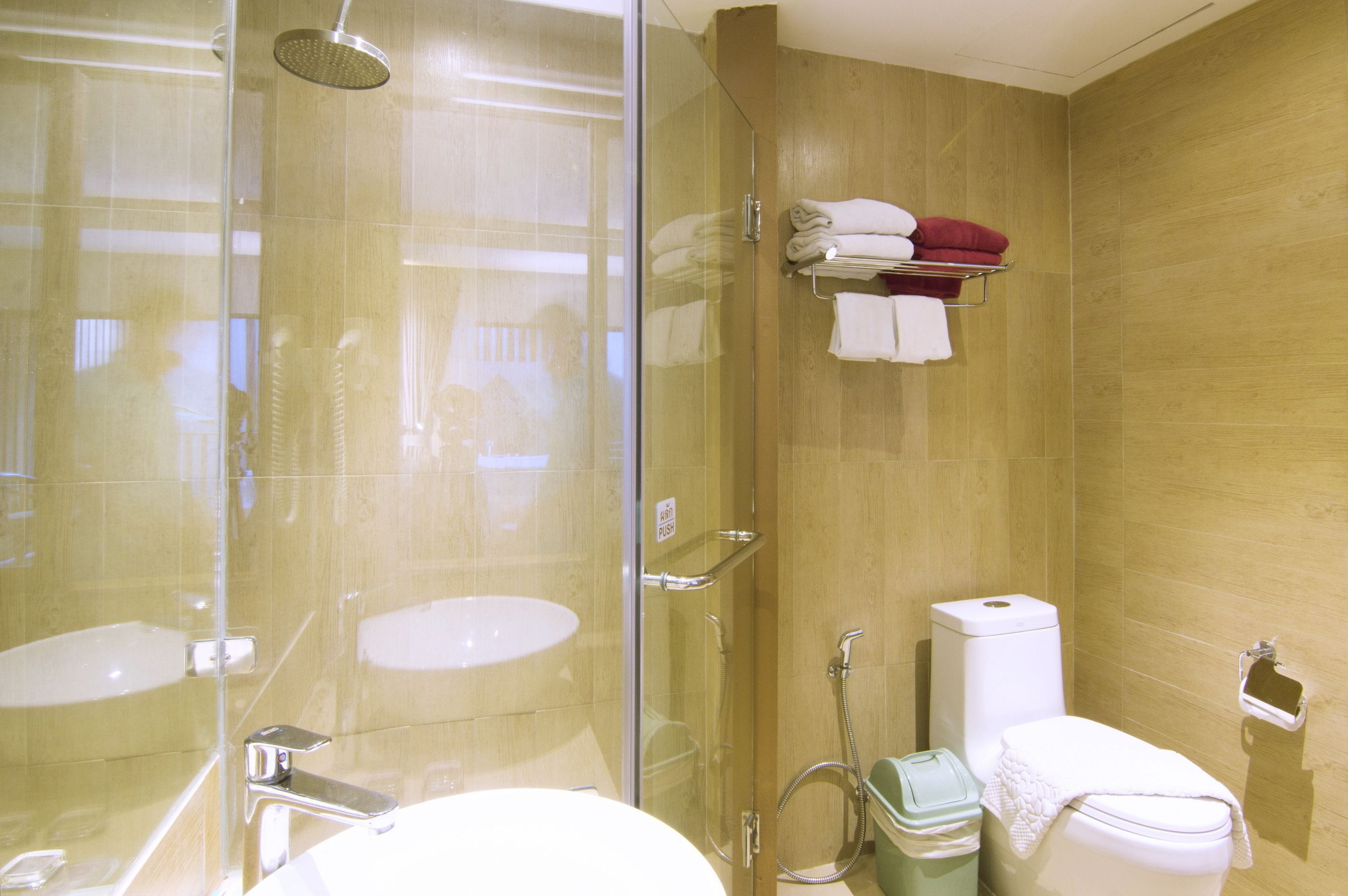 Un baño moderno con ducha de vidrio, lavamanos e inodoro.