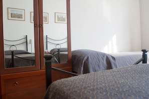 A bedroom with a wooden four-poster bed, a bedside table, and a mirror reflecting the room. - Hotel Antico Acquedotto (Rome)