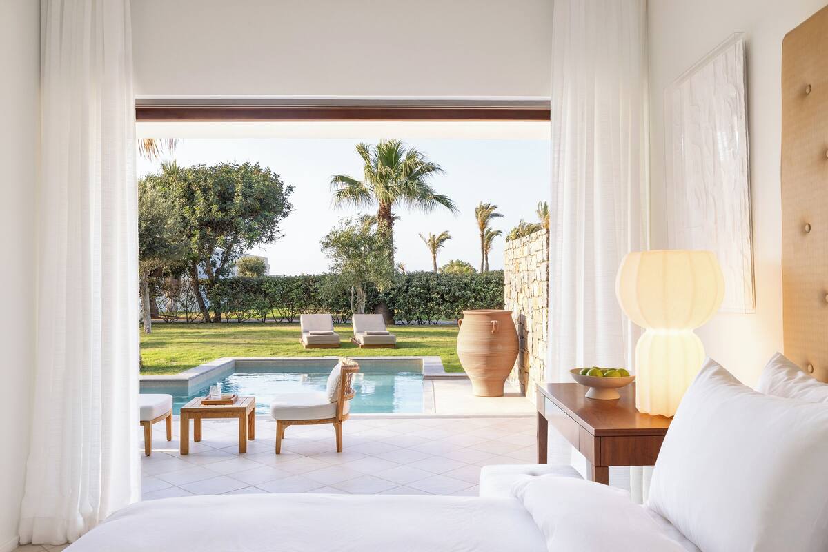 Ein Schlafzimmer mit Blick auf einen Swimmingpool und einen Garten.