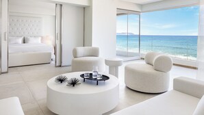 A modern hotel room with a bed, two armchairs, a coffee table, and a view of the sea. - Amirandes, A Resort to Live (Hersonissos)