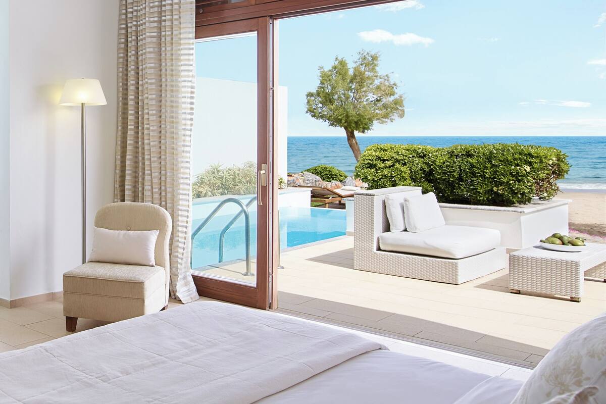 Ein Hotelzimmer mit Bett, Sessel, Sofa und Meerblick.