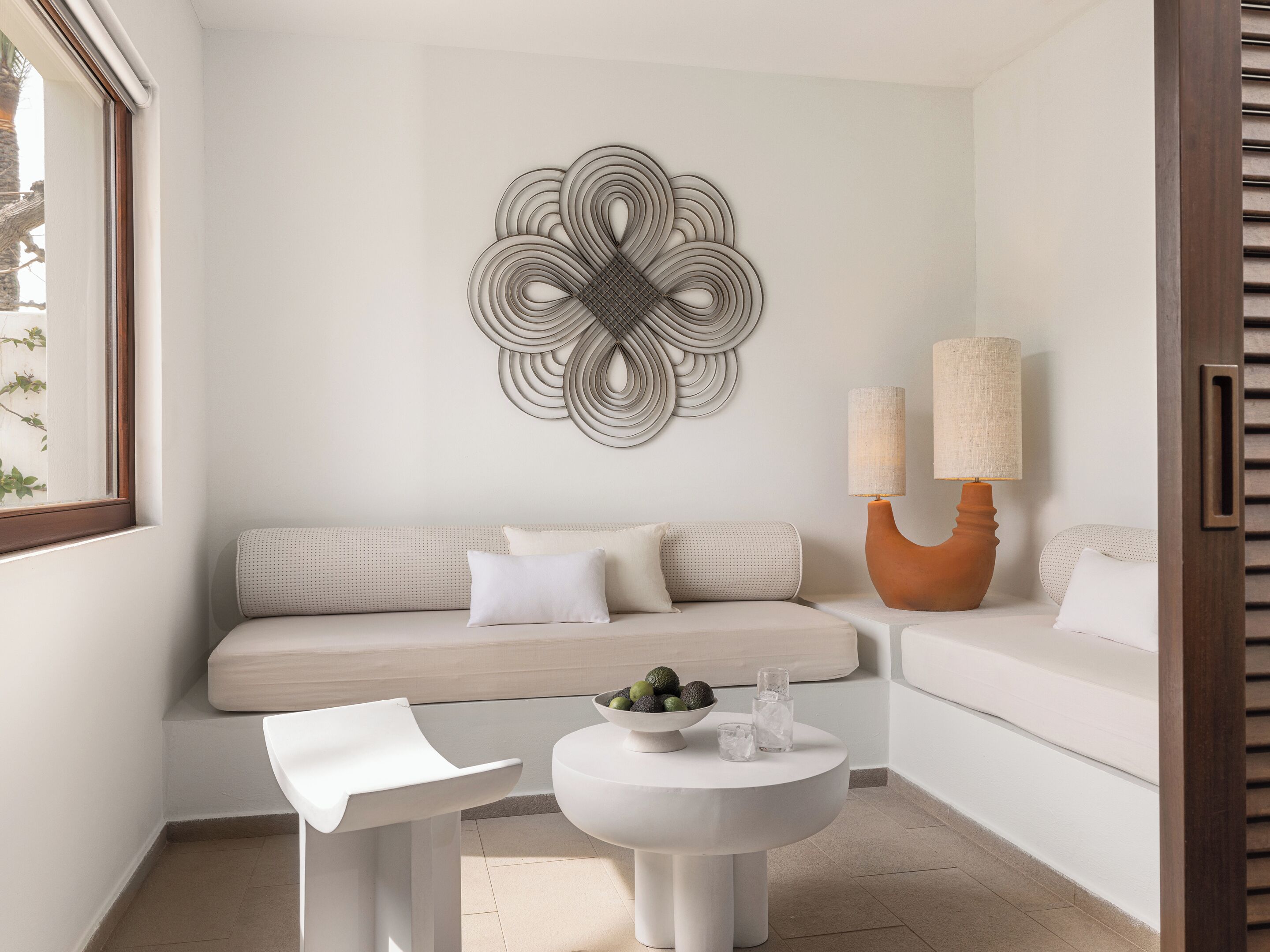 Ein modernes Wohnzimmer mit einem beigefarbenen Sofa, einem weißen Couchtisch und einer Wanddekoration.