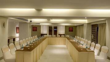 A conference room with a long table and chairs, equipped with water bottles and glasses.