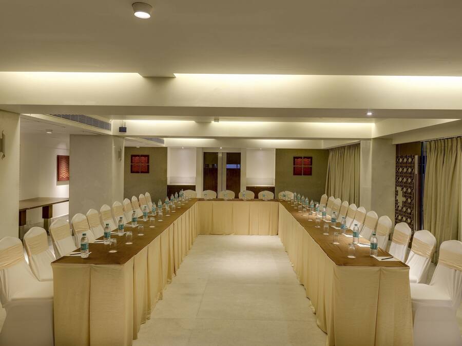 A conference room with a long table and chairs, equipped with water bottles and glasses.
