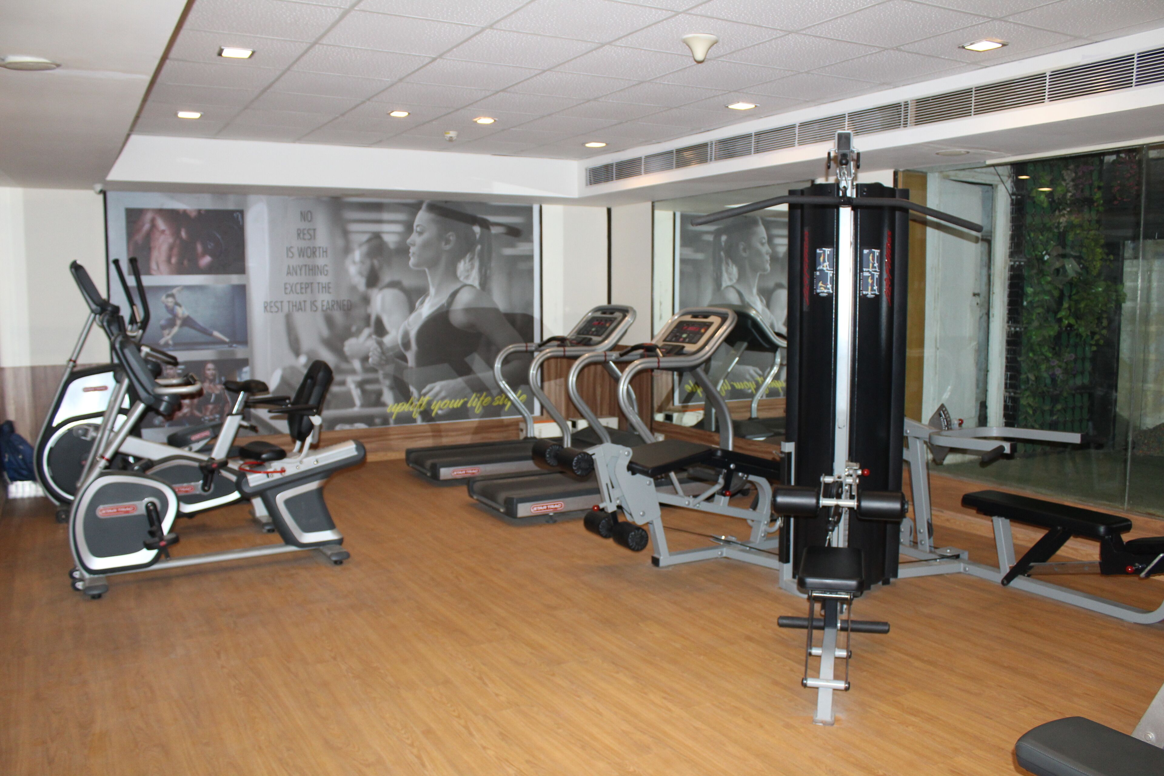 Ein Fitnessstudio mit Laufbändern, Crosstrainern und Gewichten.