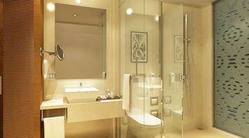 Ein modernes Badezimmer mit einer Duschkabine aus Glas, einem Waschtisch mit Spiegel und einer Toilette.