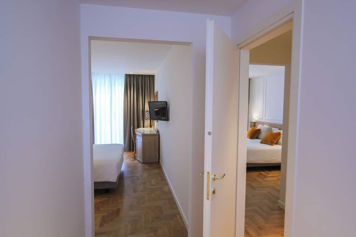 Una habitación de hotel con cama, televisión y baño.