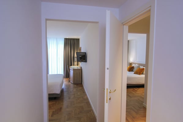 A hotel room with a bed, a TV, and a bathroom.