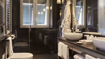 A modern bathroom with a large mirror, two sinks, and a glass-enclosed shower.
