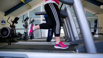 A gym with treadmills, stationary bikes, and exercise equipment.