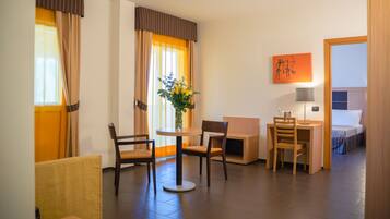 Une chambre d’hôtel comprenant un coin repas, un lit, un bureau et une chaise.