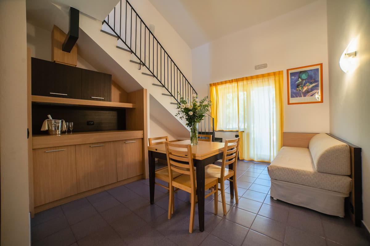 Un espacio habitable compacto con cocina, comedor y sofá.
