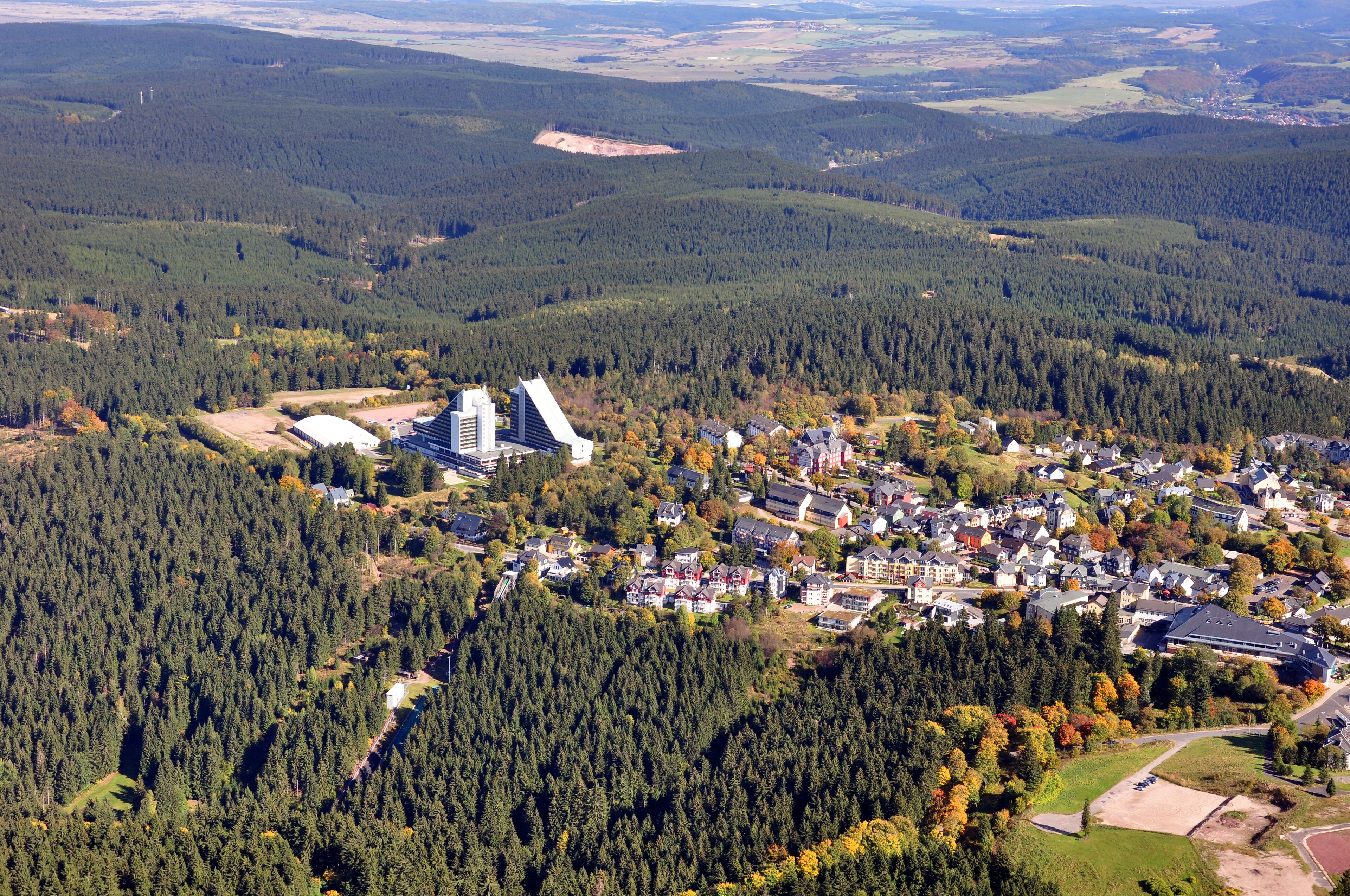 An aerial view of a residential area with a mix of houses and a large building with a triangular roof.
