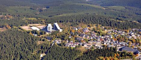 An aerial view of a residential area with a mix of houses and a large building with a triangular roof.