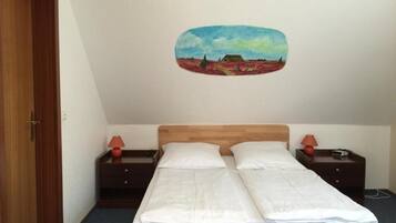 Una habitación con una cama de madera, dos mesitas de noche con lámparas y un cuadro en la pared.