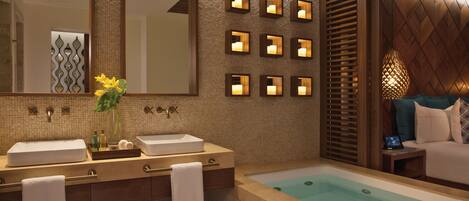Un baño moderno con dos lavamanos, una bañera grande y varias luces empotradas.