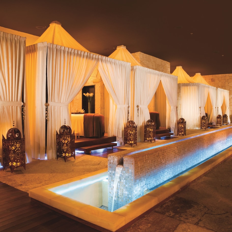 A spa area with multiple treatment rooms, each with a canopy and a small pool.