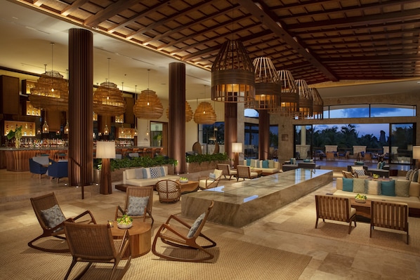 A spacious lobby with a bar area, seating arrangements, and large windows offering views of the outdoors. - Secrets Maroma Beach Riviera Cancun - Adults Only - All inclusive (Playa del Carmen)