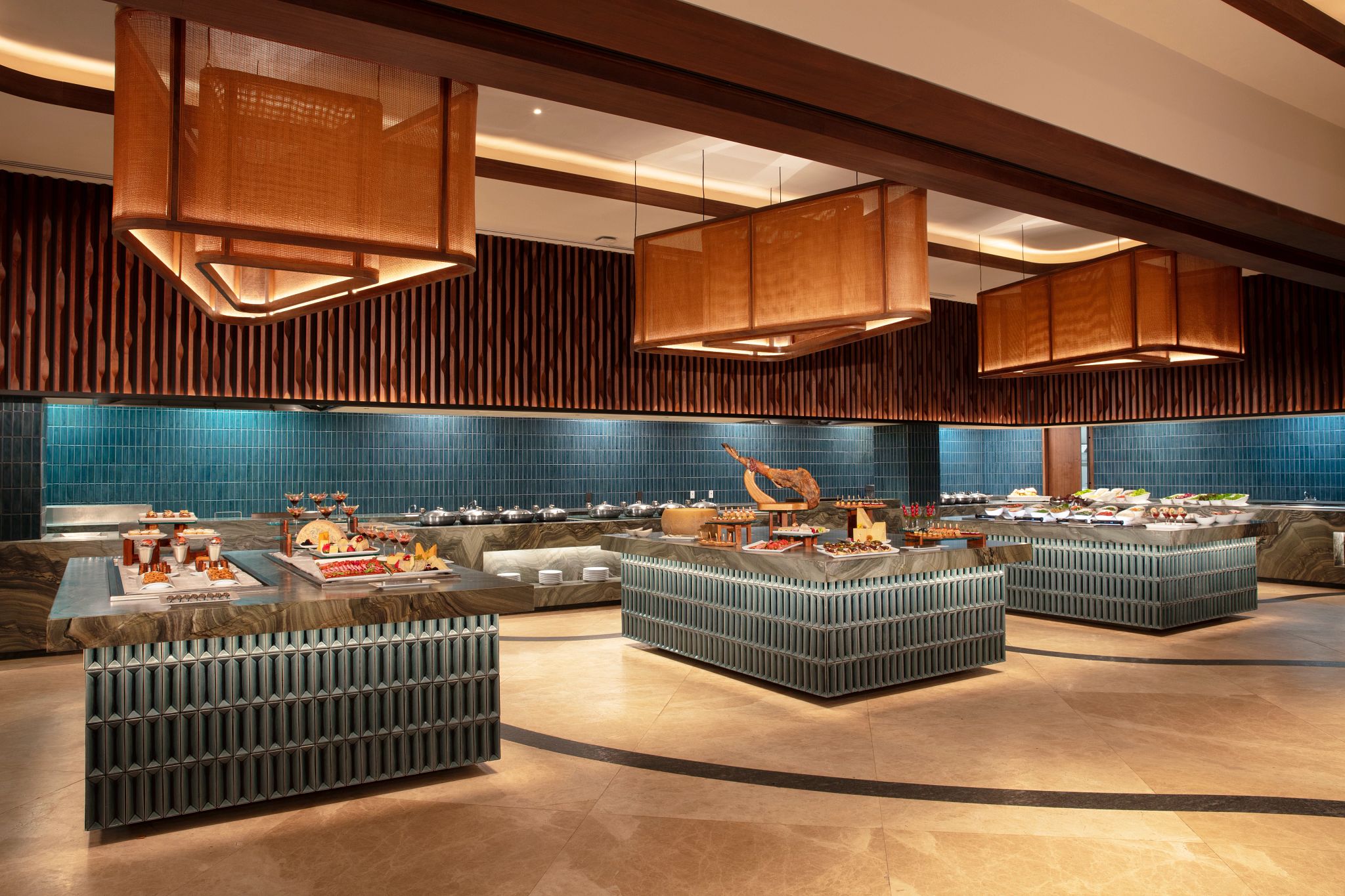 Eine moderne Hotelhalle mit einer zentralen Rezeption, Sitzbereichen und einer blauen Fliesenwand.