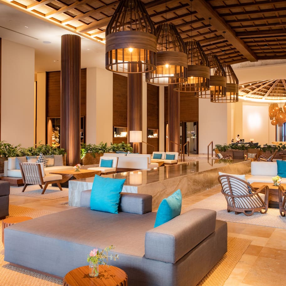 A spacious lobby with modern furniture, including sofas and chairs, and a central seating area with a coffee table.