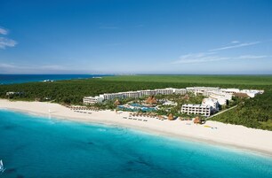 Un resort con alojamiento frente a la playa, piscina y acceso directo a la playa.