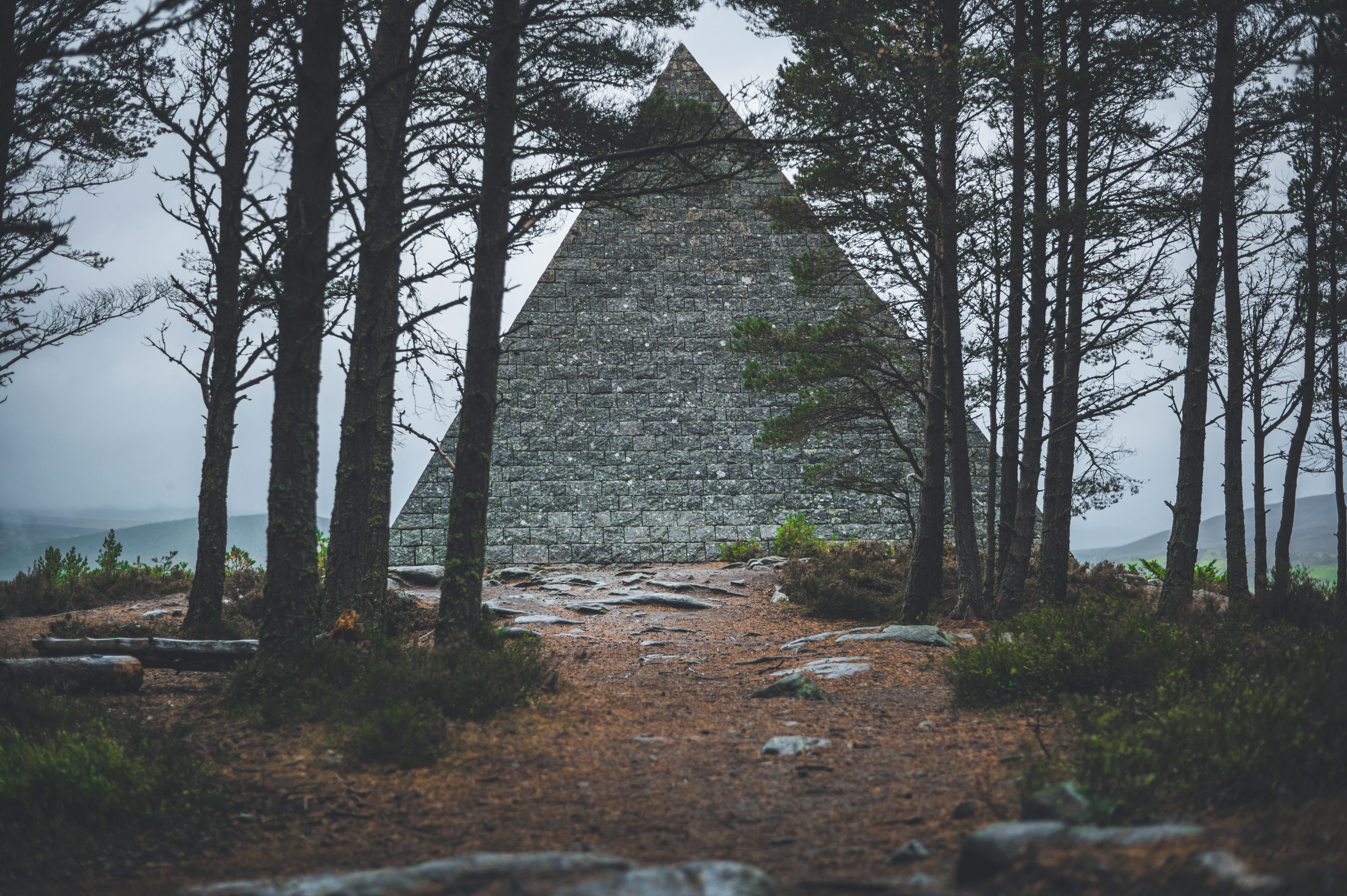 Una pirámide de piedra rodeada de árboles.