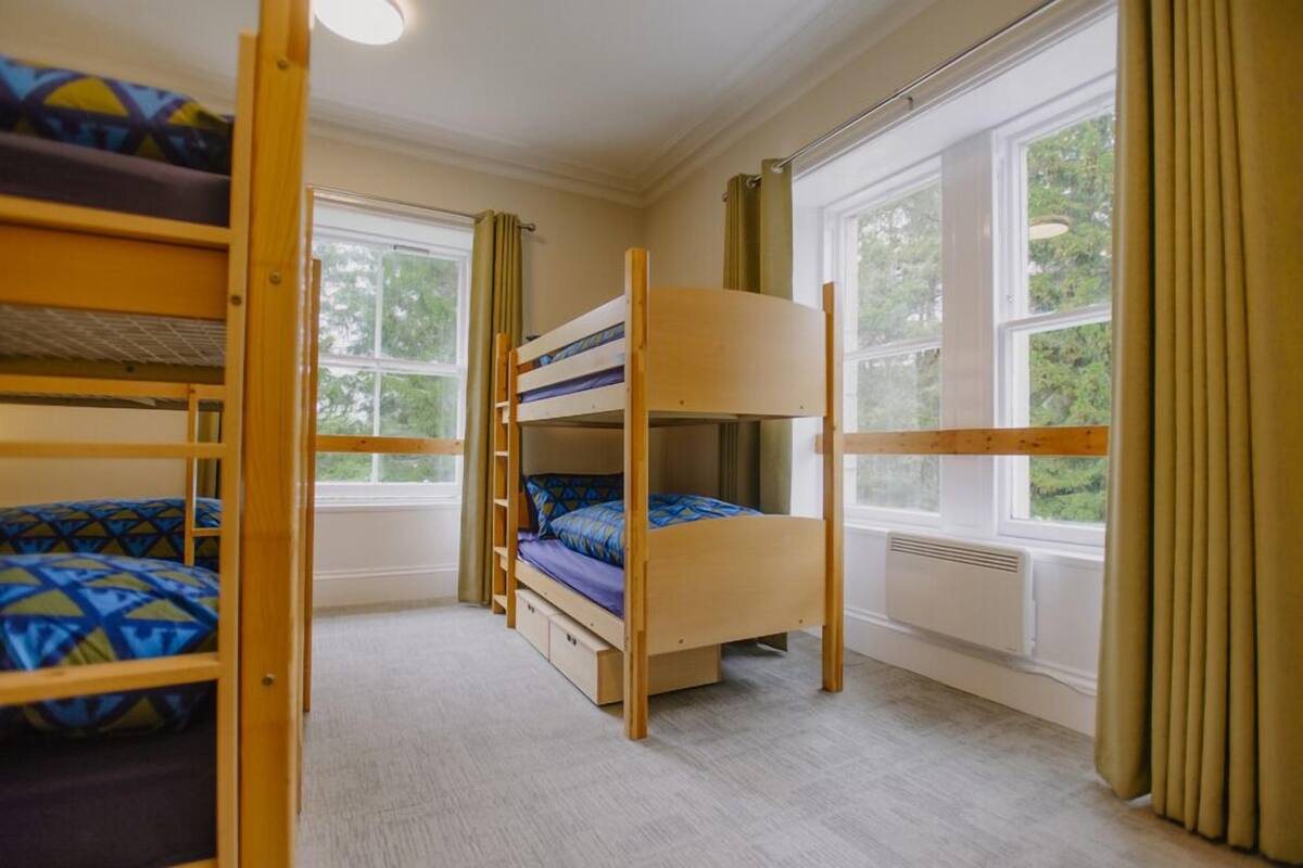 A bunk bed room with a window and curtains.