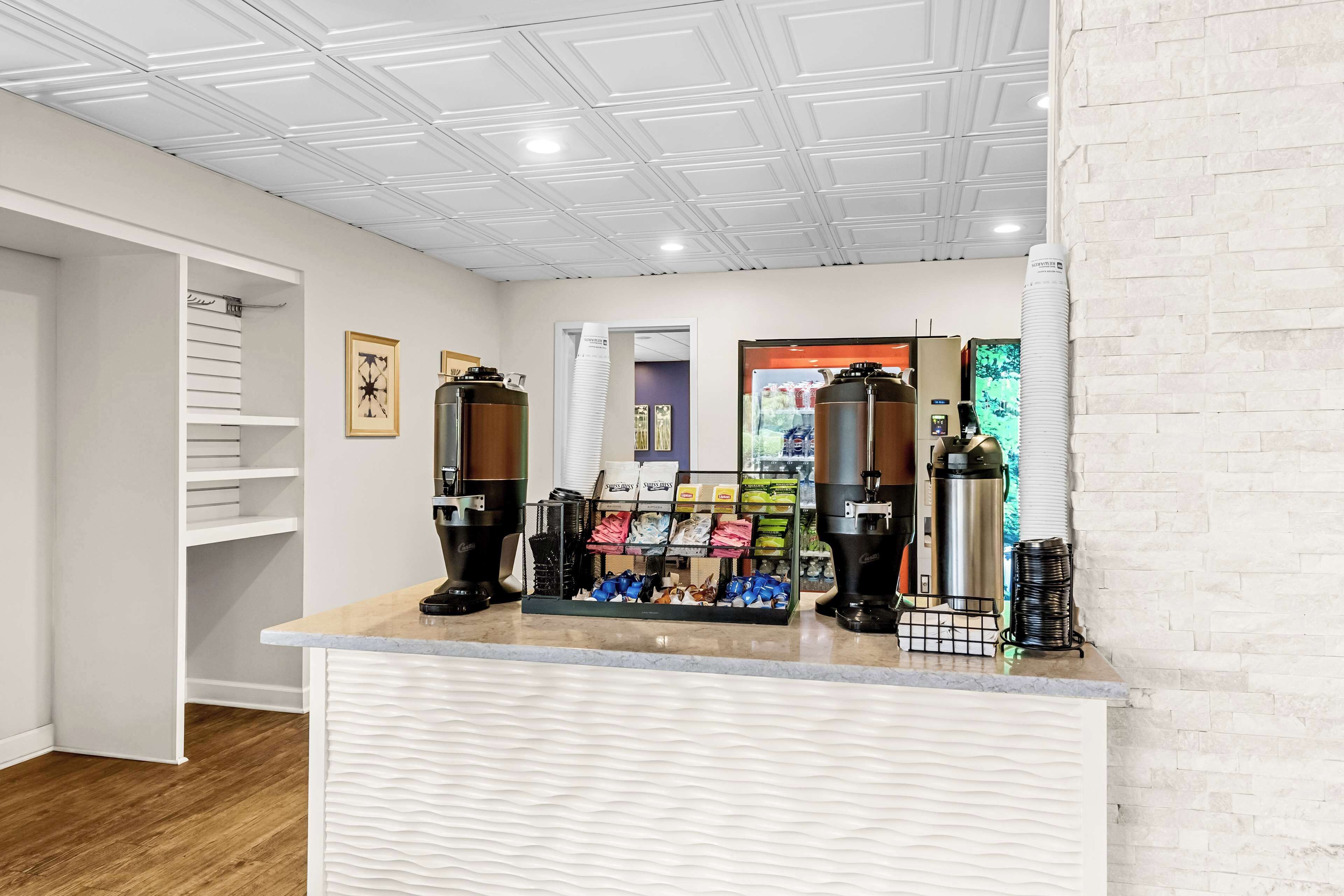 Een net, modern koffiehuis interieur met een witte toonbank, koffieapparatuur en diverse verpakte producten.
