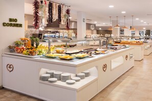 A buffet area with a variety of food items and a heart-shaped decoration on the counter. - Palm Garden Apartments (Alcúdia)