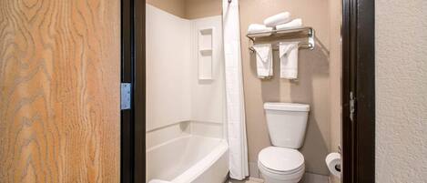 A bathroom with a bathtub, toilet, and a shower curtain.
