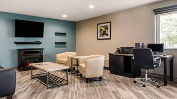 Un salon moderne doté d’une cheminée, de sièges confortables, d’un téléviseur à écran plat et d’un bureau avec un ordinateur.