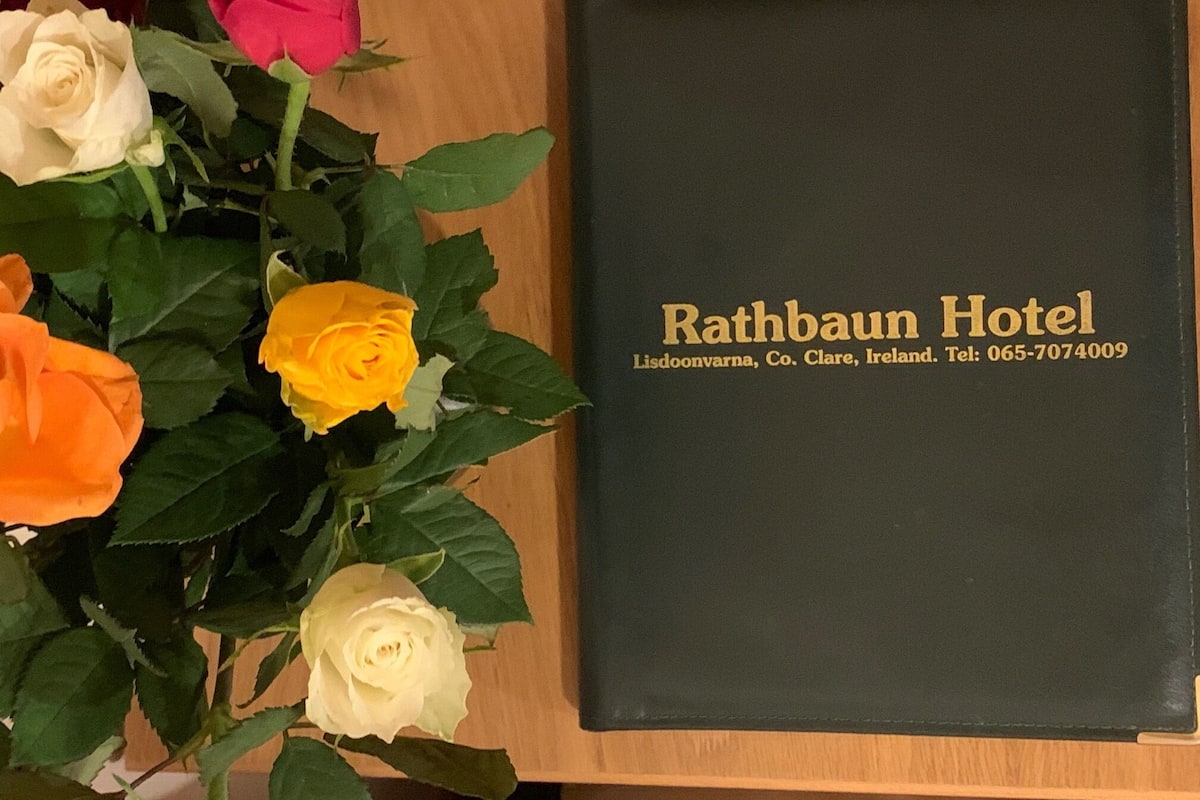 A black book titled "Rathbaun Hotel" with contact information.