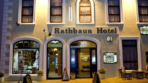 The exterior of the Rathbaum Hotel with its classic architecture, including arched windows and a sign above the entrance. - Rathbaun Hotel (Lisdoonvarna)