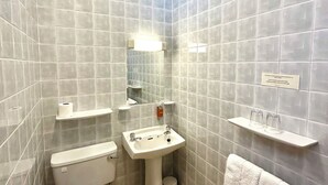 A bathroom with a toilet, sink, and towel rack.