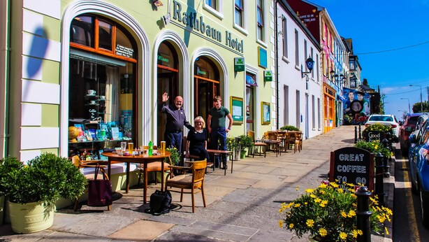 The exterior of the Rathbaum Hotel with outdoor seating and a sign advertising great coffee.