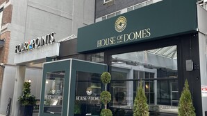 Een gebouw met een bord waarop 'House of Domes' en 'Four Points by Sheraton' staat.