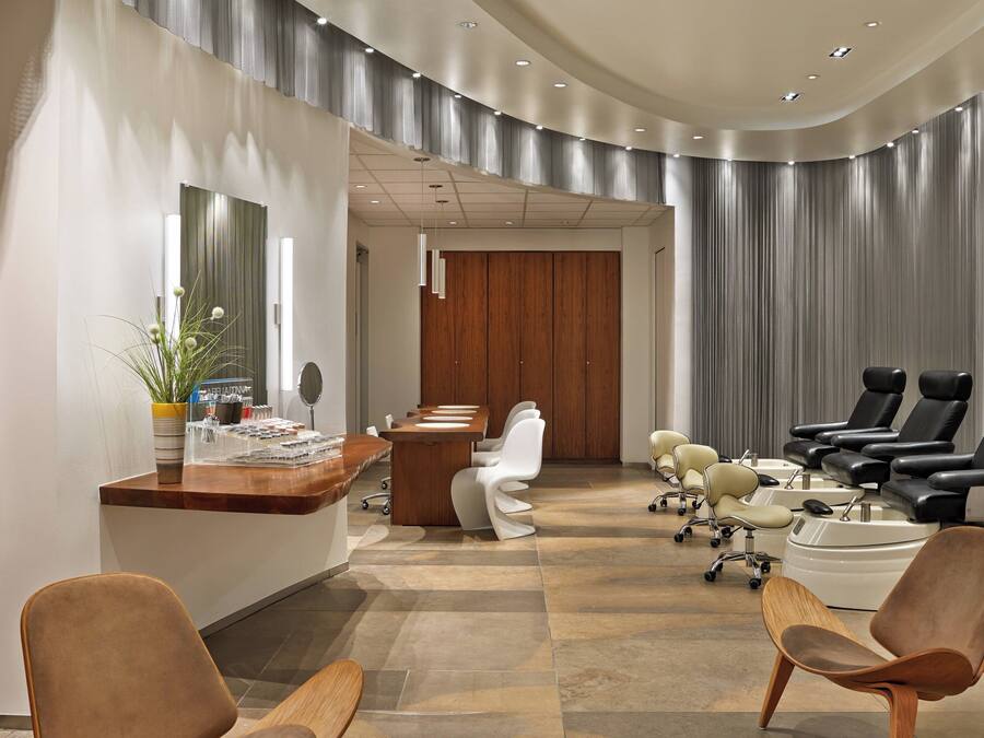 Interior moderno de una clínica dental con mostrador de recepción, zona de espera y sillas de tratamiento.
