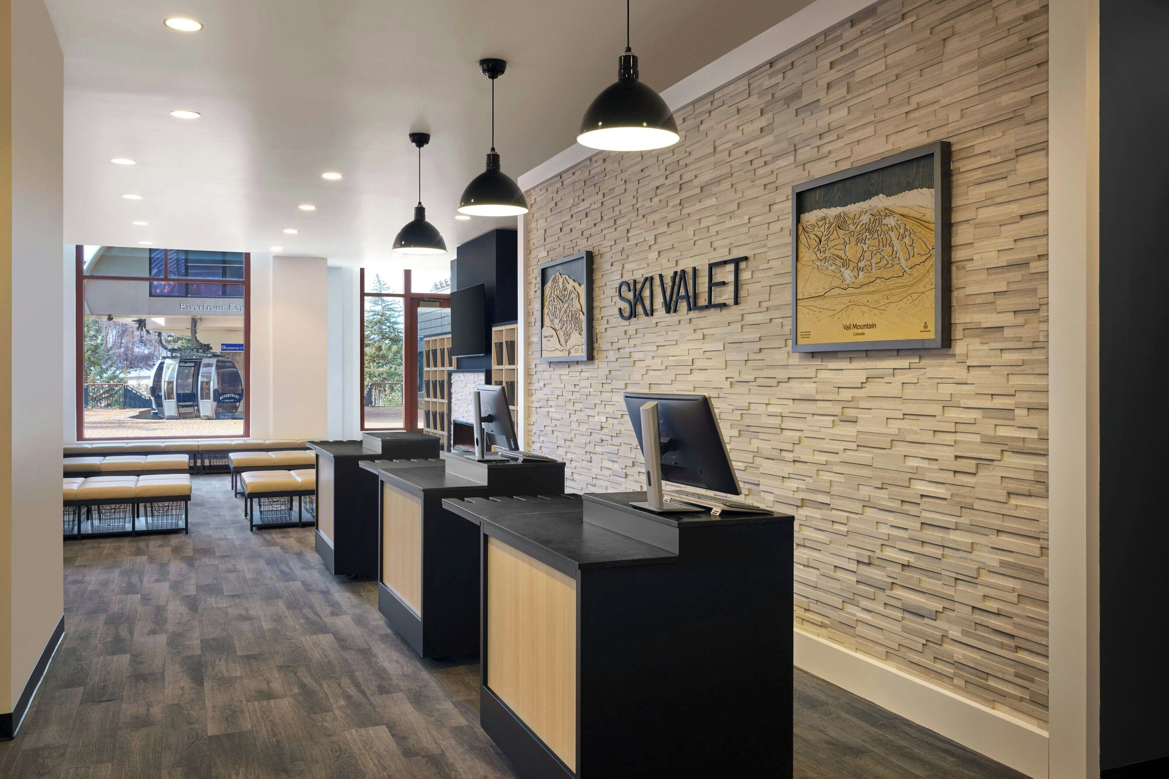 A reception area with a brick wall, a framed artwork, and a desk with a computer.