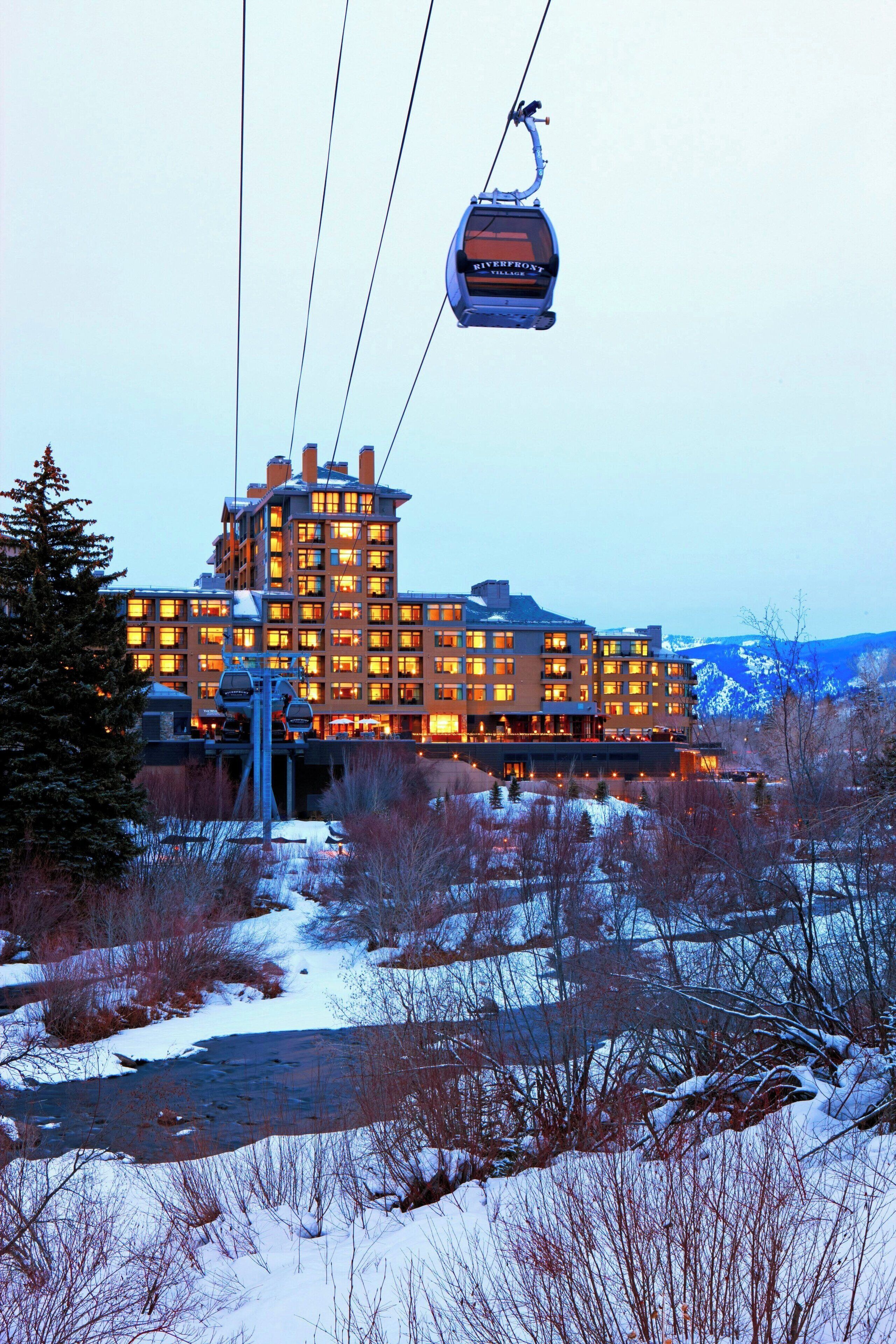 A large hotel with multiple floors, a ski lift, and a snowy landscape.