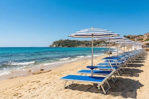 Praia particular, espreguiçadeiras, guarda-sóis, toalhas de praia 