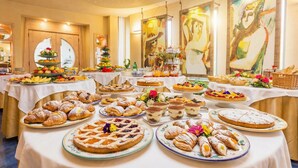 Un bufé con diversas bollerías, postres y frutas.