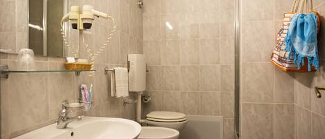 Un baño con lavamanos, inodoro y ducha.