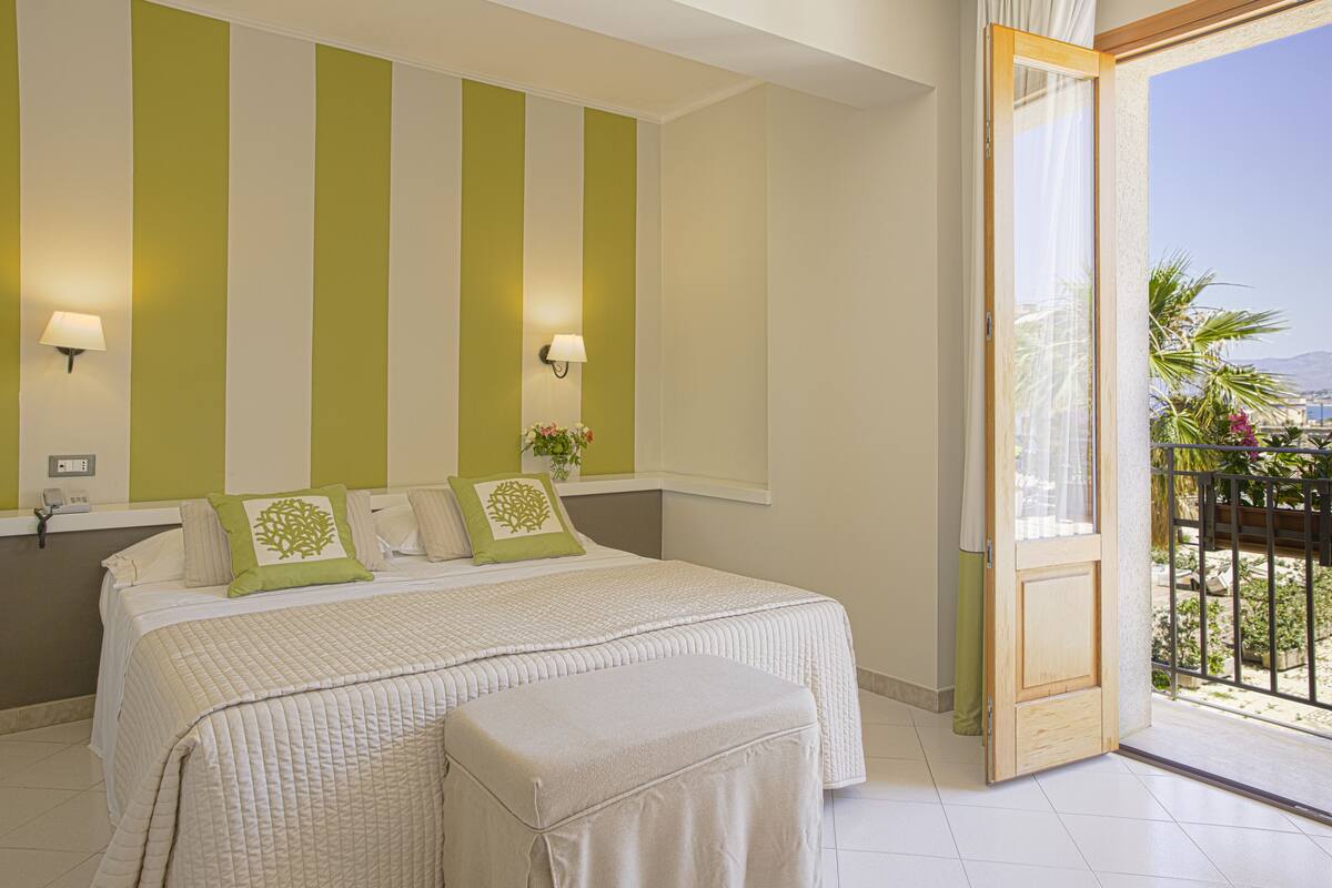 Une chambre à coucher avec un grand lit, deux tables de chevet et une fenêtre donnant sur l’extérieur.