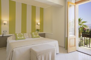 A bedroom with a large bed, two bedside tables, and a window with a view of the outdoors.