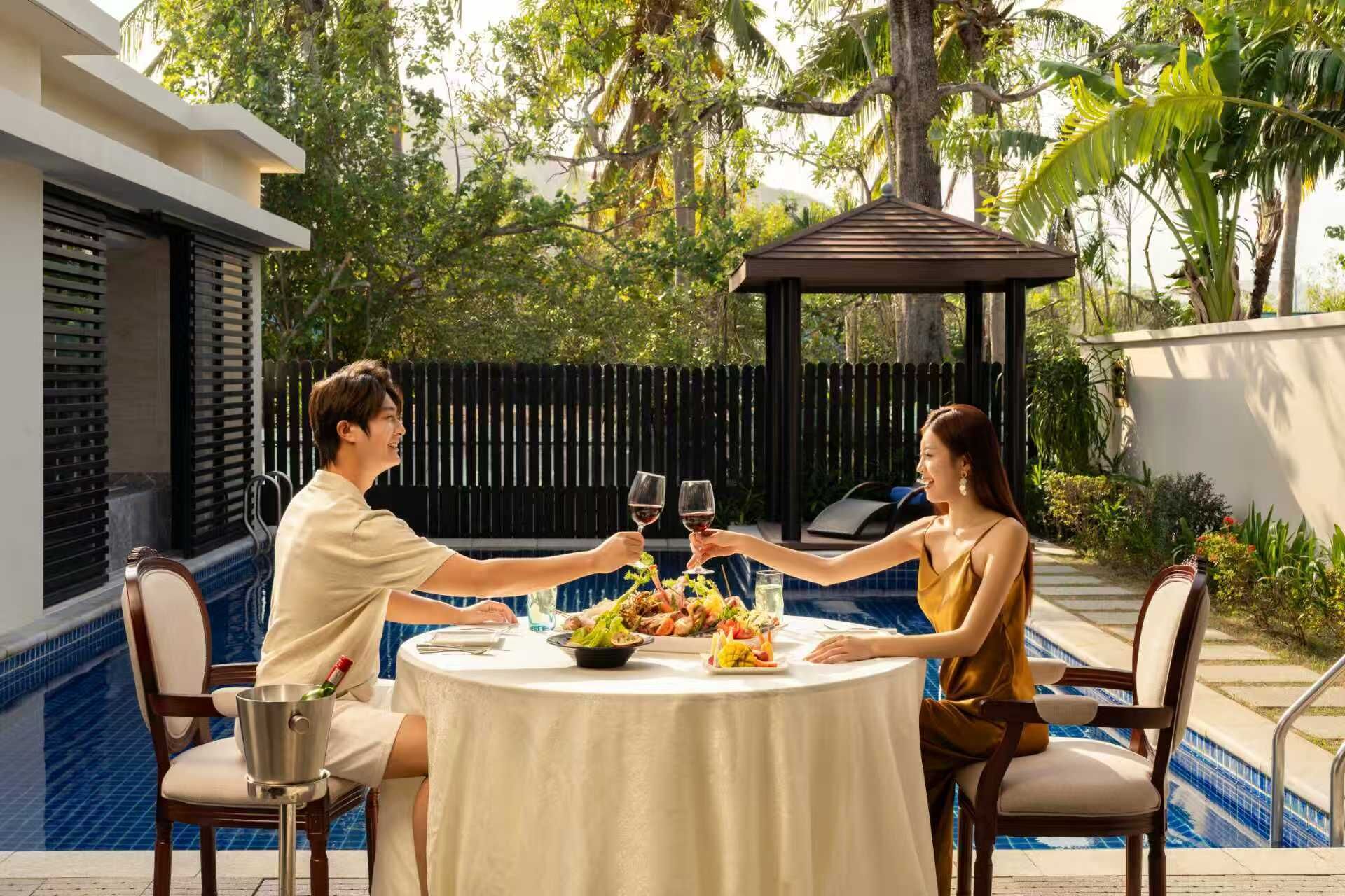 Una mesa de comedor con vista a la piscina, rodeada de sillas, y un pabellón al fondo.