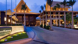 Un hotel de estilo arquitectónico tradicional, con una entrada destacada y un letrero iluminado.