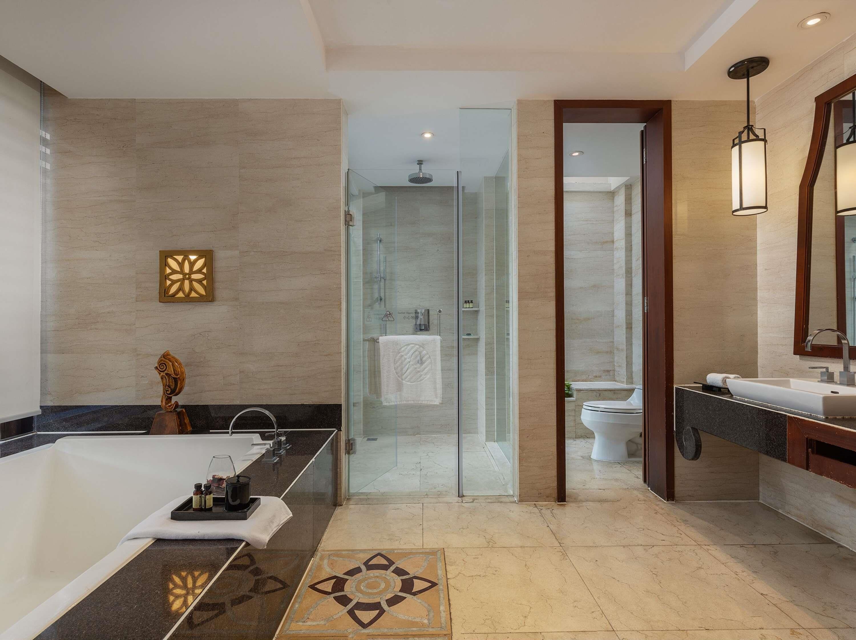 A modern bathroom with a glass-enclosed shower, a freestanding bathtub, and a vanity with a large mirror.