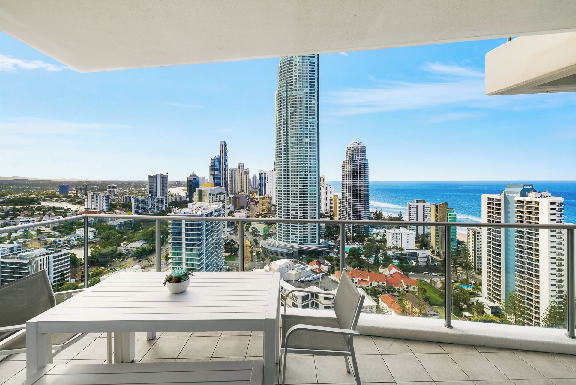 Un balcón con vista a un horizonte urbano y el océano.