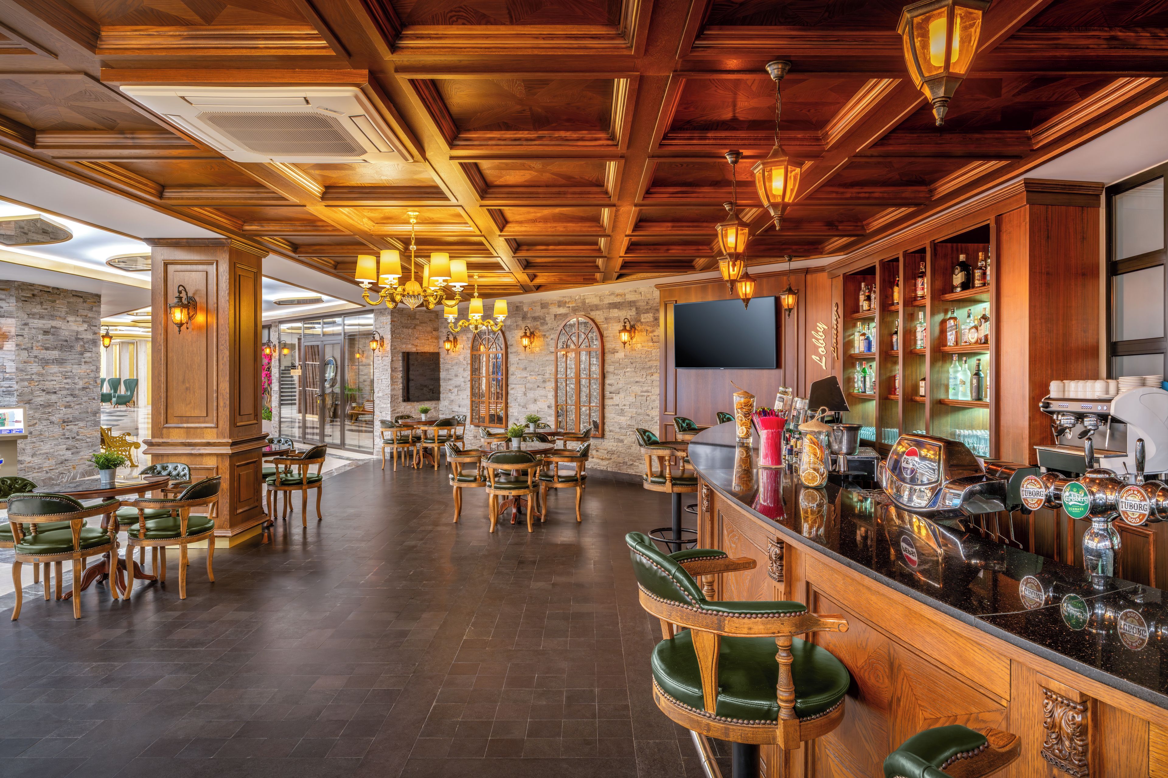 A bar area with wooden bar stools, a counter with taps, and a stone wall.