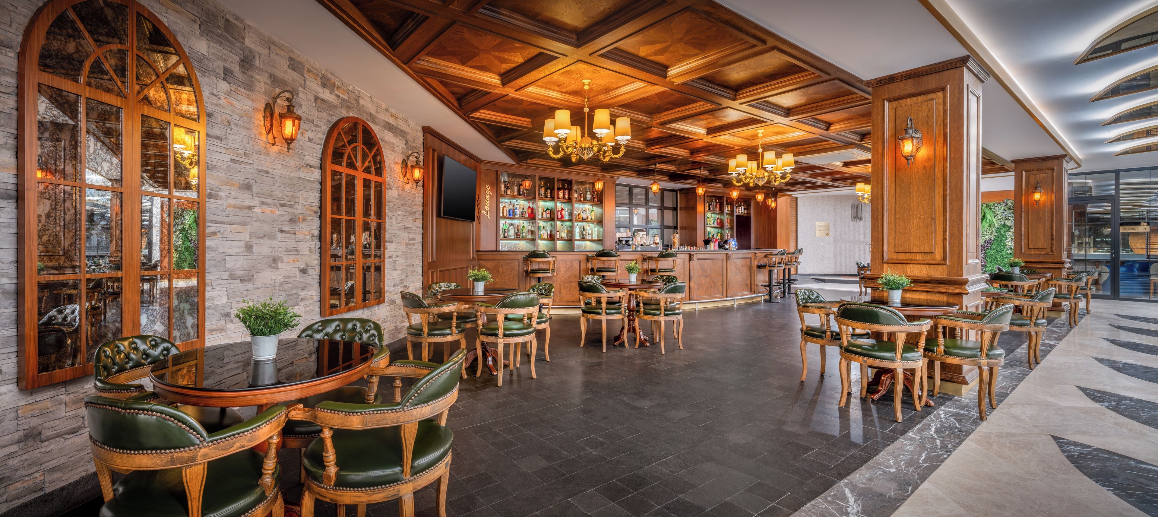 A bar area with wooden furniture, a stone wall, and a chandelier.